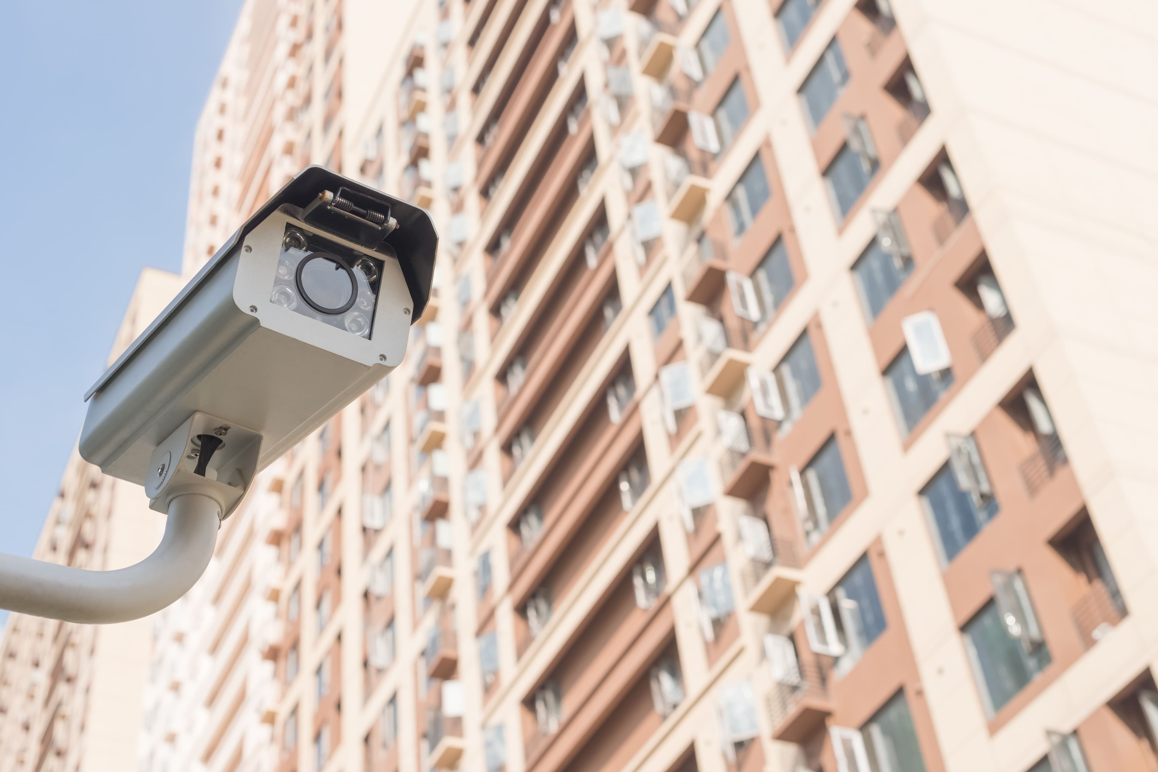 Câmera de segurança instalada na área externa de um condomínio residencial, simbolizando o papel da tecnologia no monitoramento preventivo e na proteção do patrimônio coletivo.